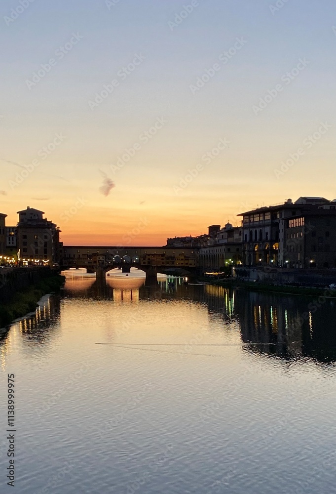 Naklejka premium sunset over Ponte Vecchio with river reflections 