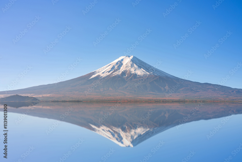 A mirrored reflection of snow capped Mount Fuji on a cold and sunny autumn winter morning with clear blue sky, no clouds or people and copy space. cool temperature and isolated image with mist A mirrored reflection of snow capped Mount Fuji on a cold and sunny autumn winter morning with clear blue sky, no clouds or people and copy space. cool temperature and isolated image with mist