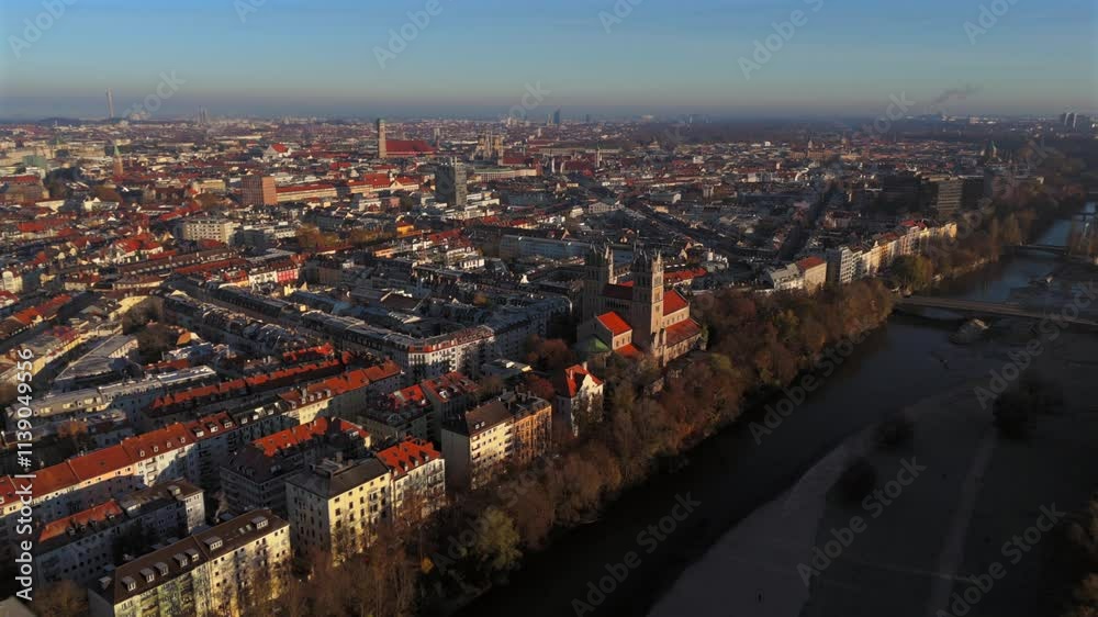 Kath. Pfarramt St. Maximilian Katholische Kirche in Munchen, Bayern, Deutschland Luftaufnahme. Aerial view of St. Maximilian in Munich with distinctive towers at sunrise, surrounded by autumn colors. 