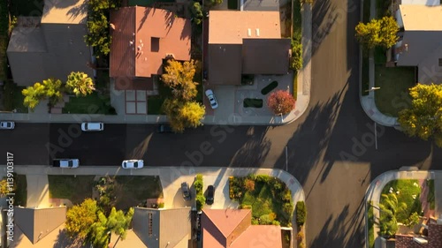 Absolutely stunning aerial view beautifully showcases a serene and tranquil suburban neighborhood in Los Angeles, featuring charming homes bathed in the warm golden glow of a picturesque sunset photo