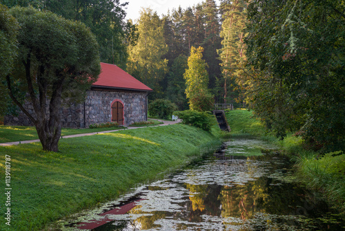 A traditional stone barn for storing flax on the shore of the pond 