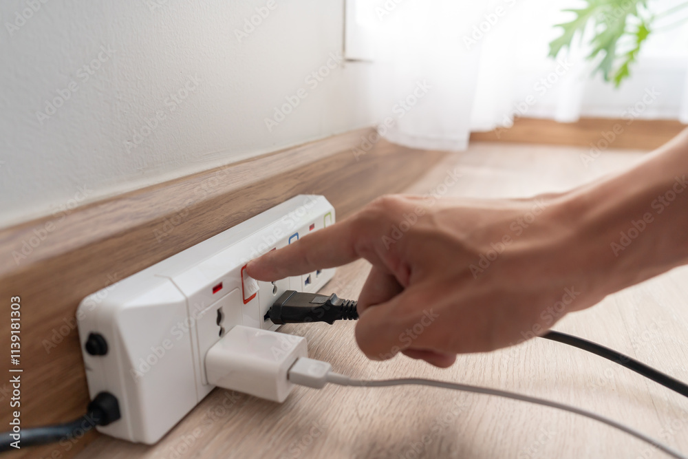 Man is turning off the light switch after not using it, energy saving, saving money, environmental conservation, reducing global warming, power
