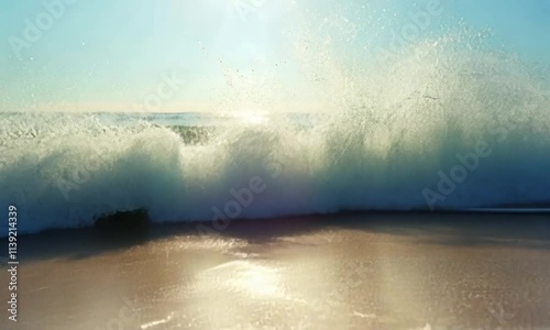 Ocean Wave Crashing on Sandy Beach at Sunrise