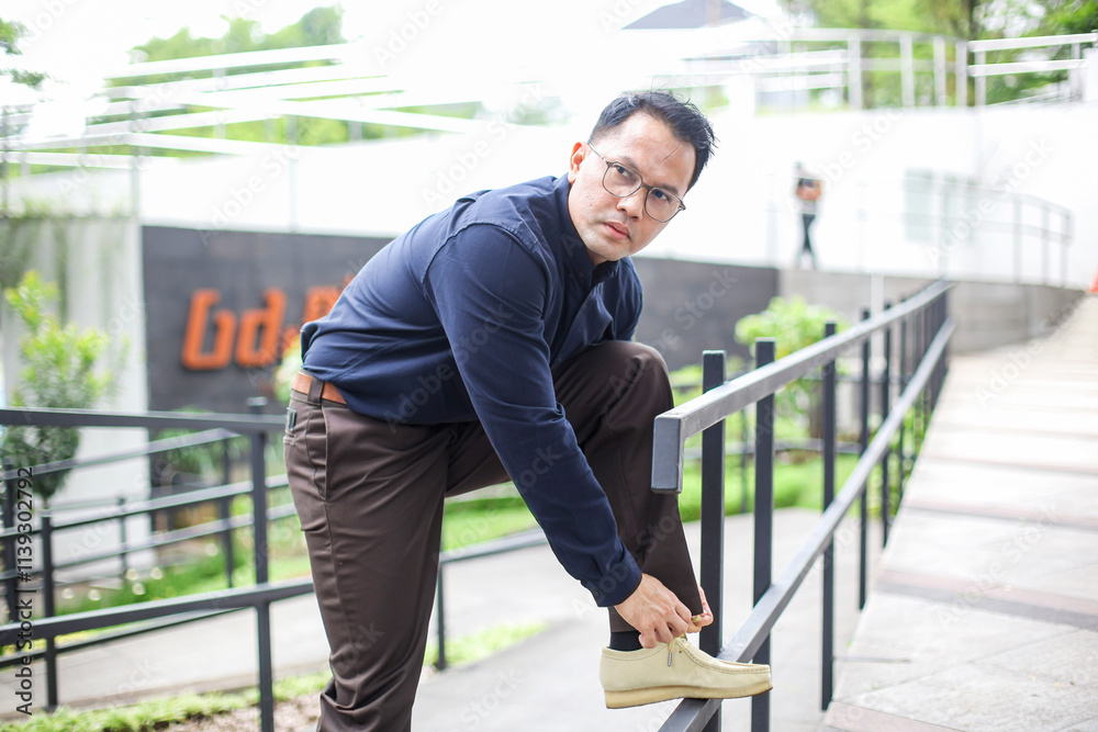 Asian Man Wear Formal Clothes Tying Shoes While Looking Away