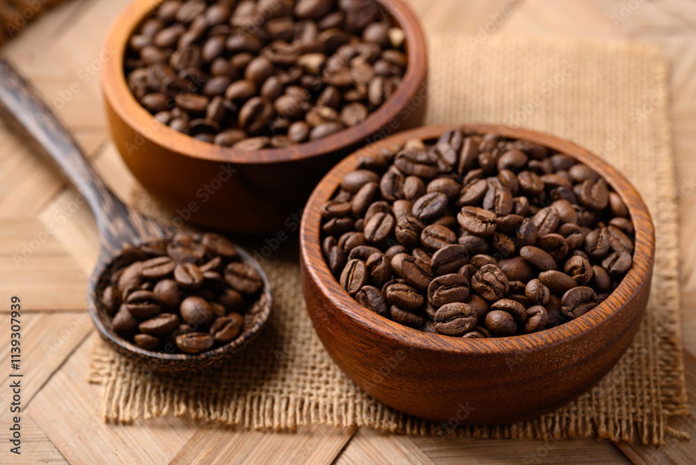 Roasted coffee beans in wooden bowl with spoon, Arabica coffee Roasted coffee beans in wooden bowl with spoon, Arabica coffee