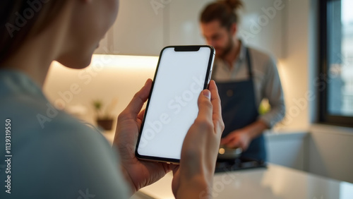 A person following a cooking recipe on their smartphone, with fresh ingredients and cooking utensils spread out on a kitchen counter.