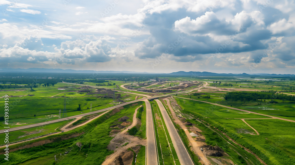 Drone viewpoint reveals an extensive infrastructure development with geometric landscape features and open sky, highlighting construction activity in a green rural area Drone viewpoint reveals an extensive infrastructure development with geometric landscape features and open sky, highlighting construction activity in a green rural area