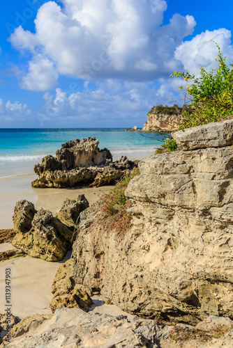 A rocky beach with a large rock in the foreground