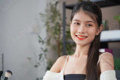 Tableau sur toile Asian woman influencer beauty blogger live streaming reviews her cosmetics on on