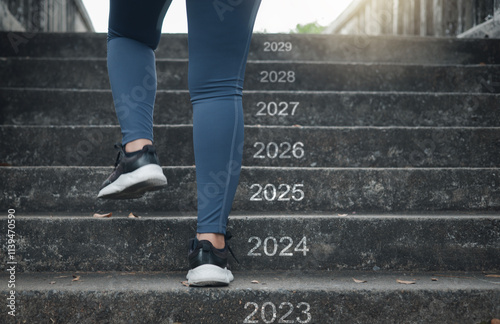 A woman steps up a staircase with new numbers on each step representing the new year 2023, 2024, 2025, 2026, 2027, 2028, 2029.