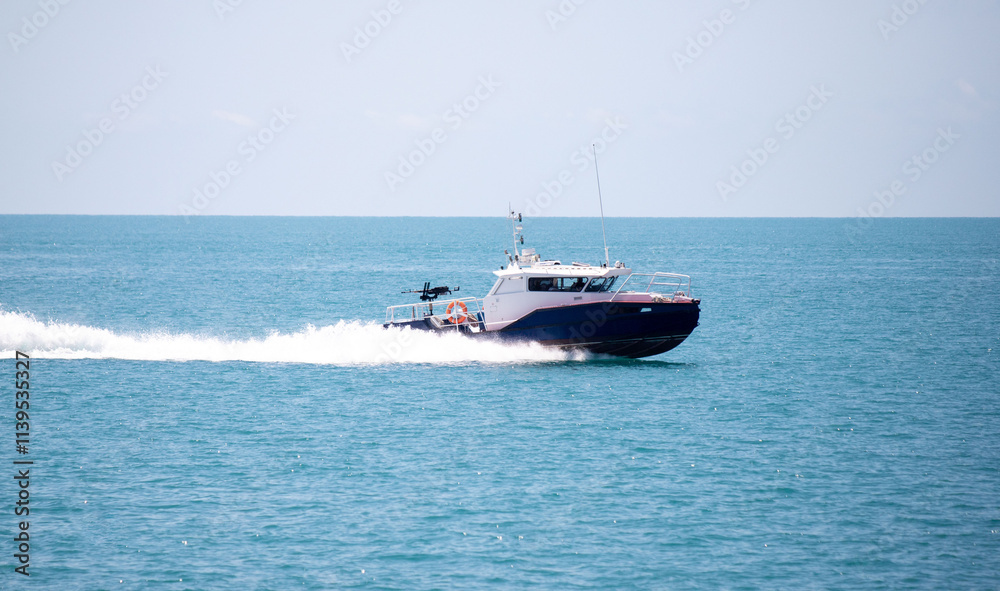 A boat is traveling through the ocean with a man in the front