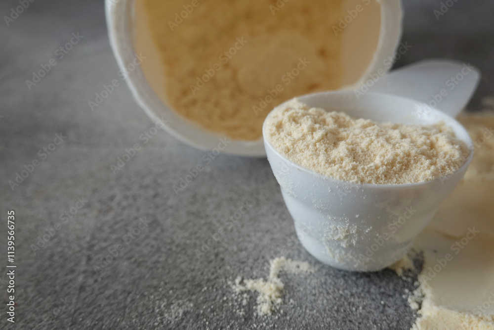 Open container with colostrum powder and measuring scoop Open container with colostrum powder and measuring scoop