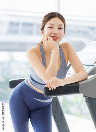 Asian young beautiful cheerful woman, active sport girl in sportswear exercise standing pose at treadmill training in fitness gym or living room smiling look at camera health care wellness lifestyle.