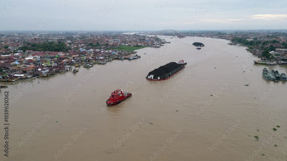 Barges carrying coal pass the Ampera Bridge on the Musi River Barges carrying coal pass the Ampera Bridge on the Musi River