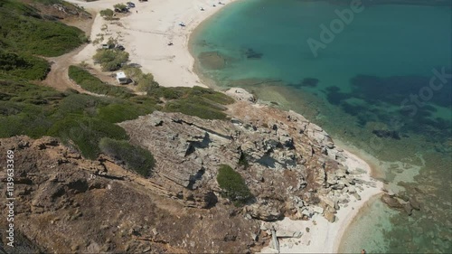 Reveal Xeromilos Beach in Agioi Apostoloi, Evia, with the backdrop of newly constructed hotel suites, blending modern luxury with the serene coastal charm photo