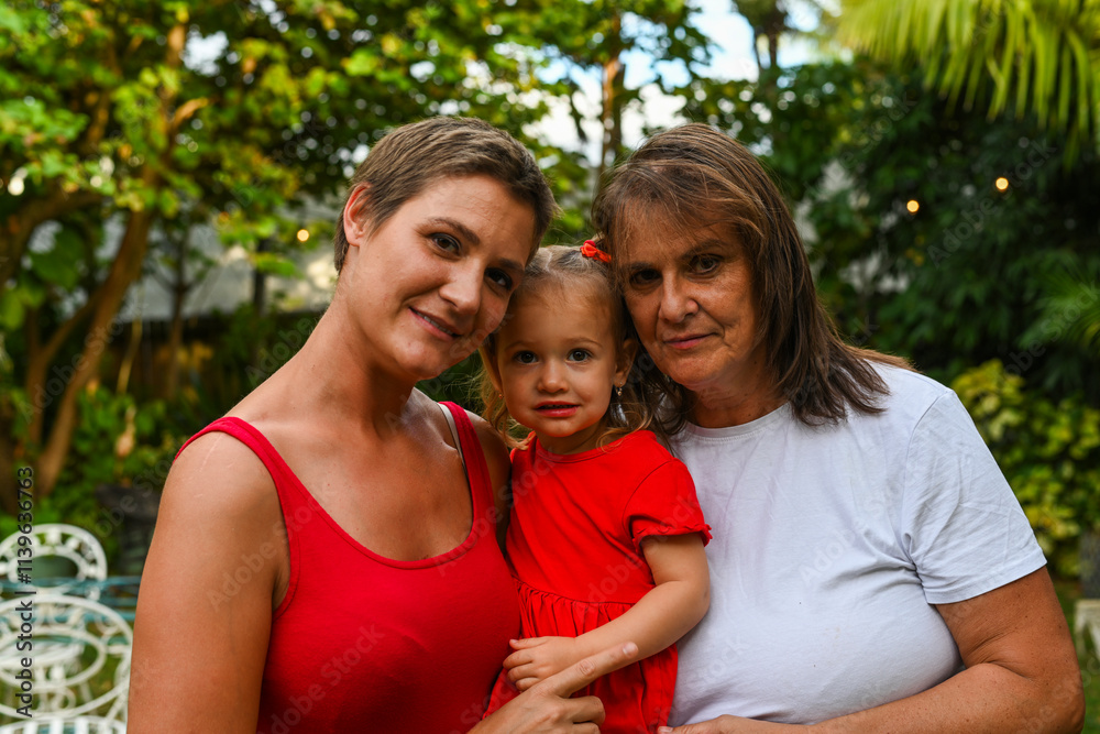 Fototapeta premium Three Generarions embrace in backyard