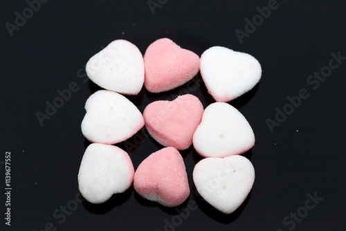 Heart-Shaped Sugar Candy on Black Reflective Surface Close-Up View