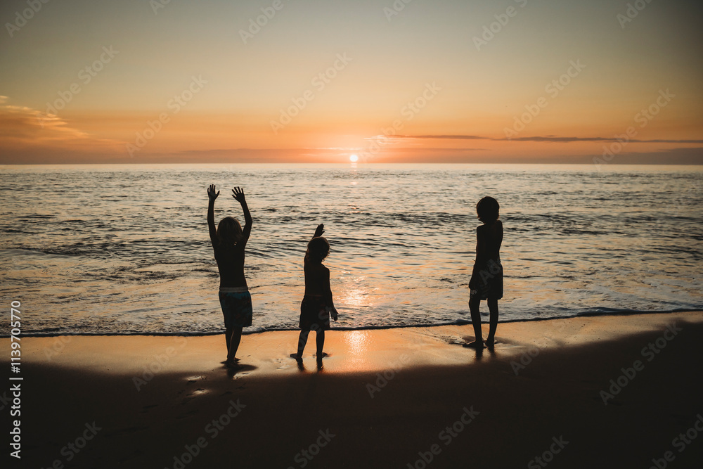 Children standing at beach watching stunning sunset in Spain Children standing at beach watching stunning sunset in Spain