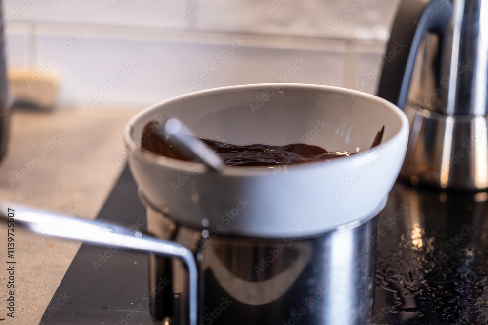 Fototapeta premium Stockholm, Sweden Chocolate melts over a steam bath on the stove for baking.