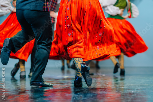  Latvian Folk dancers in vibrant green and red traditional costumes perform a lively dance on stage, showcasing cultural heritage and energy. photo