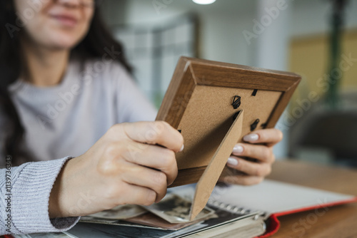 Фотография close up of woman look at photos in picture frame
