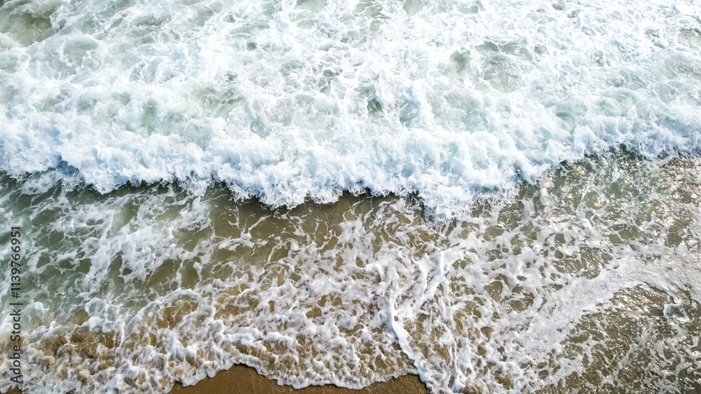 Aerial view of ocean waves crashing onto a sandy beach, symbolizing tranquility and escape, perfect for summer vacation themes Aerial view of ocean waves crashing onto a sandy beach, symbolizing tranquility and escape, perfect for summer vacation themes