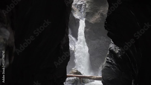 Wallpaper Mural Water rushes down a waterfall flowing through a narrow rock formation, surrounded by towering cliffs and mist, capturing nature in a secluded area. Torontodigital.ca