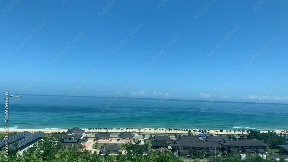 Panoramic, scenic view of sandy Mangsang Beach next to the Donghae Expressway road. Traditional Korean houses. Motion of East Sea waves. Solar panels station. Donghae, South Korea Panoramic, scenic view of sandy Mangsang Beach next to the Donghae Expressway road. Traditional Korean houses. Motion of East Sea waves. Solar panels station. Donghae, South Korea