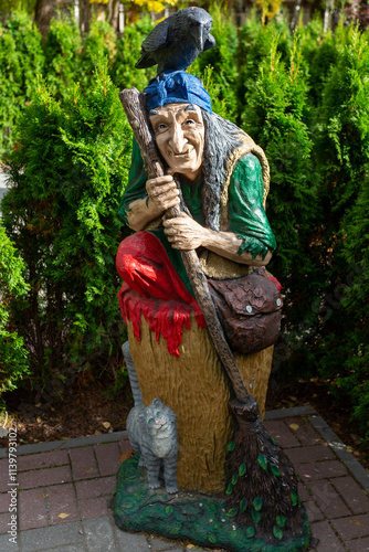 Wooden figure of Baba Yaga in the park against the background of trees