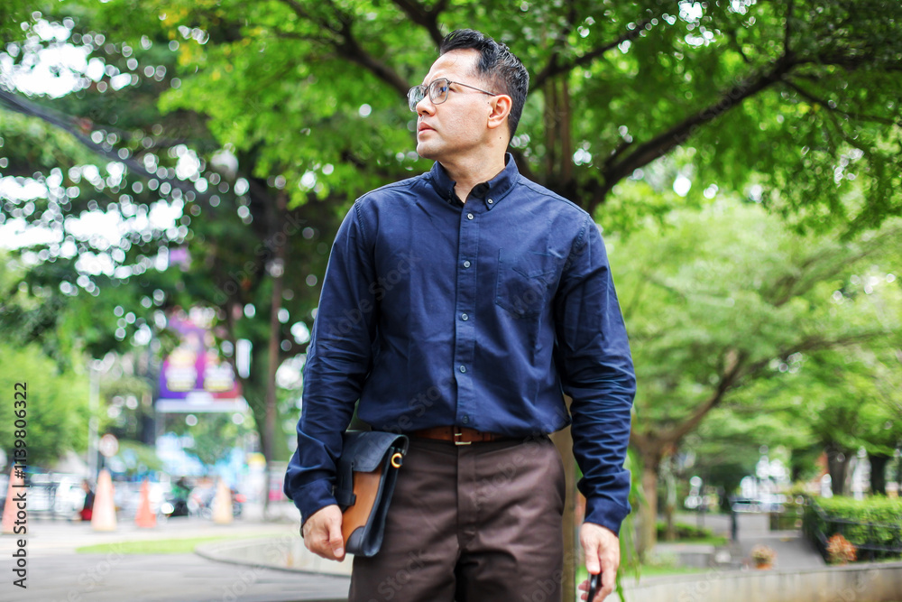 Portrait Of Businessman Walking on Park While Holding Briefcase Portrait Of Businessman Walking on Park While Holding Briefcase