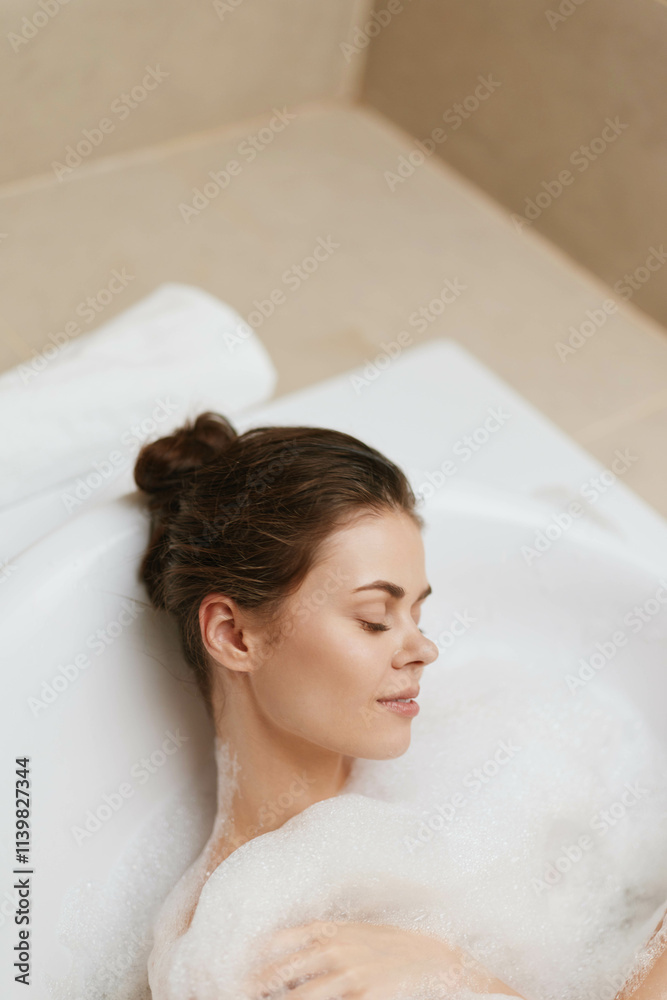 Naklejka premium Relaxed European woman enjoying a bubble bath in a serene bathroom setting, feeling peaceful and rejuvenated. Self-care and wellness concept.