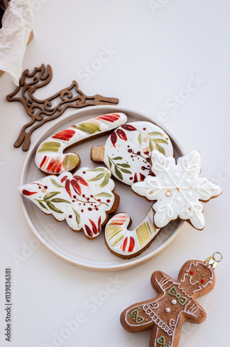 Cozy Christmas Photo with Hand-Painted Gingerbread Cookies on a Plate, Surrounded by Christmas Decor on a White Background