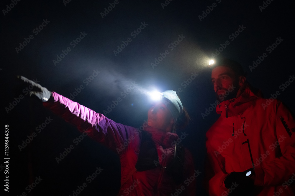 Runners tired of breathing after training look at their tech sports smart watch in night on maintain Runners tired of breathing after training look at their tech sports smart watch in night on maintain