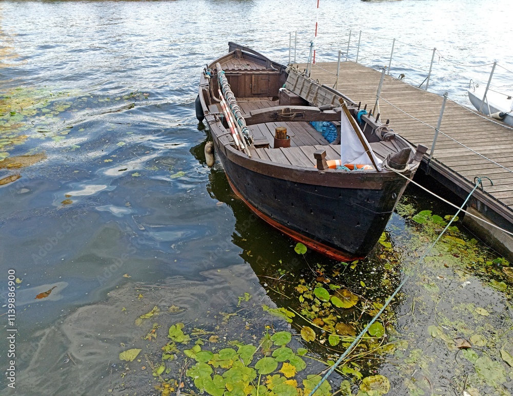 a wooden boat moored to a wooden pier a wooden boat moored to a wooden pier