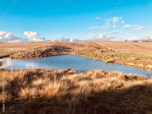 Highveld landscape view of a dam surrounded by grass and blue skies, Dullstroom, Mpumalanga, South Africa photo