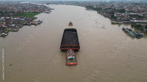 View of coal barges passing by on the Musi River photo