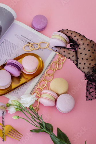 Hand in a Black Lace Glove Holding a Soft Purple Macaron, with a Gold Plate of Purple Macarons in the Background