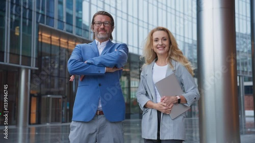 Wallpaper Mural Man and woman standing close to each other. Posing for best view. Experienced company owners. Managers. Looking at camera while smiling. Male crossing hands. Female holding laptop. Torontodigital.ca