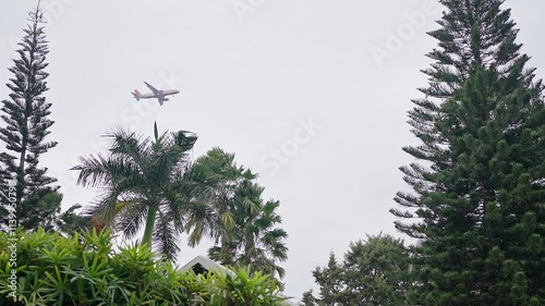 A low-angle view of a speeding airplane in the sky, approaching landing at dusk