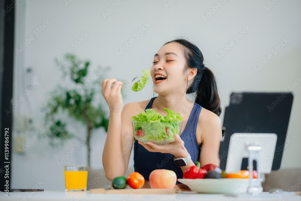wellness as a cheerful woman enjoys a salad and fruits while engaging with technology at home wellness as a cheerful woman enjoys a salad and fruits while engaging with technology at home
