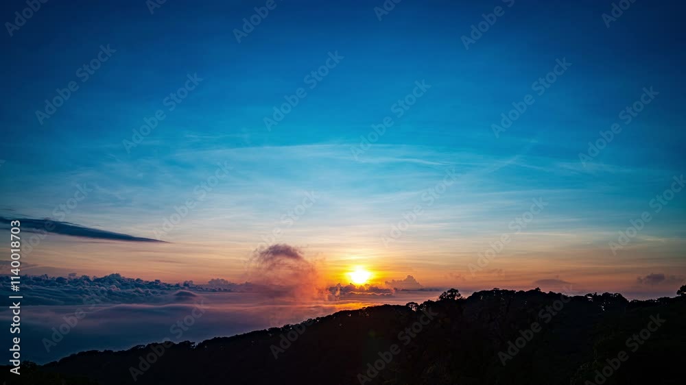 The sun sets behind a dense forest, casting a golden glow through billowing clouds and mist. This captivating scene blends warm and cool tones, creating a dramatic and serene natural landscape.
The sun sets behind a dense forest, casting a golden glow through billowing clouds and mist. This captivating scene blends warm and cool tones, creating a dramatic and serene natural landscape.