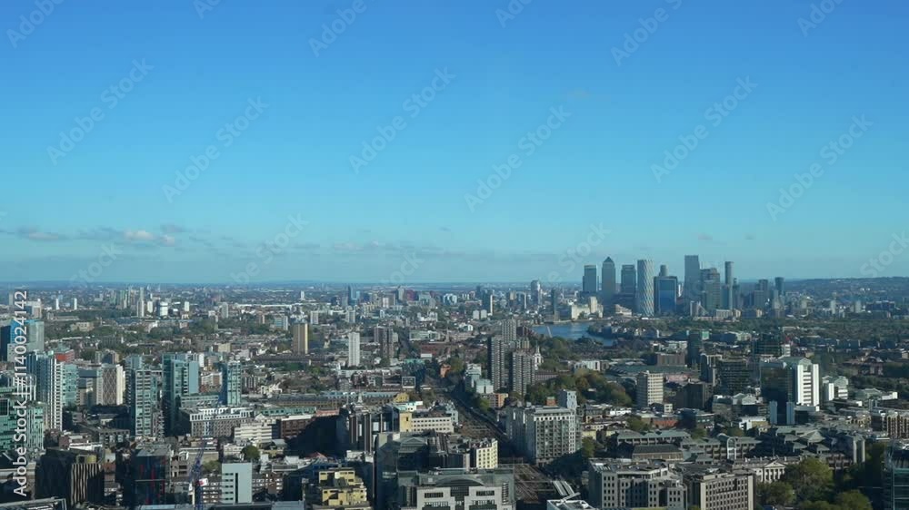 Panoramic view of London showcasing urban architecture and Canary Wharf under a clear blue sky Panoramic view of London showcasing urban architecture and Canary Wharf under a clear blue sky