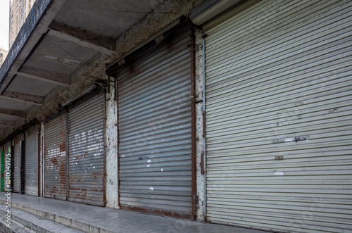 Fotografie A row of closed and shuttered storefronts on a city street