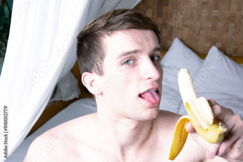 Young attractive man eating a banana. photo