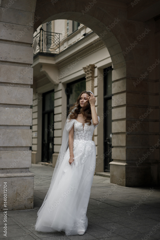 Fototapeta premium A Beautifully Elegant Bride Styled Delightfully in a Striking Architectural Urban Setting