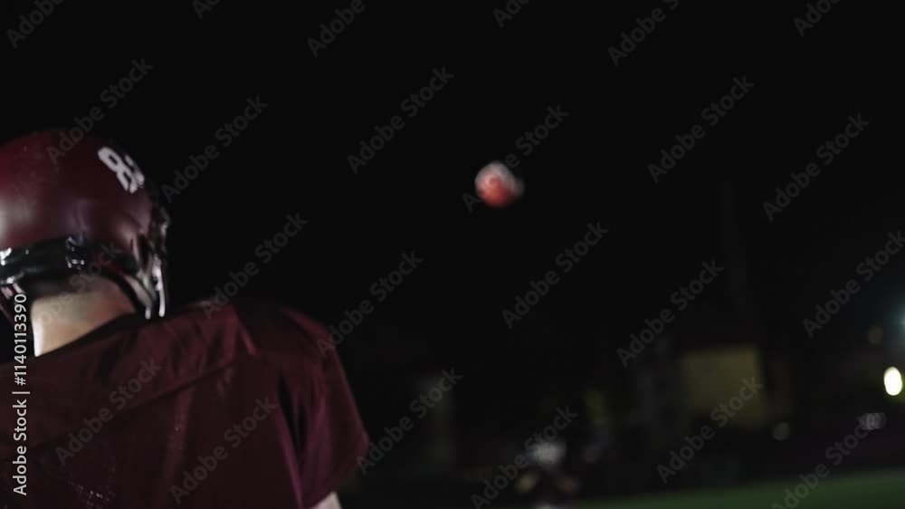 An American football player practicing throwing and catching the ball on a field An American football player practicing throwing and catching the ball on a field