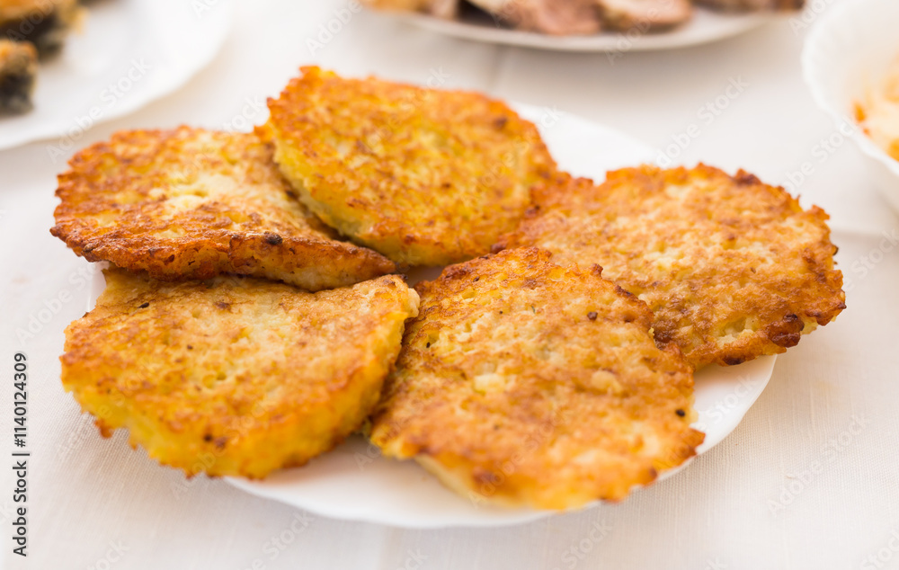 Potato pancakes with sour cream on white plate Potato pancakes with sour cream on white plate