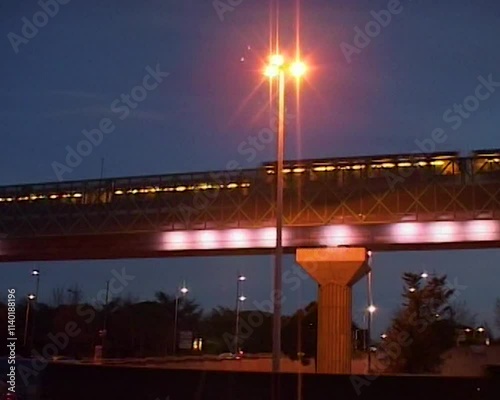 Vintage camcorder shot of aerial metro crossing over a bridge at night, Toulouse, France