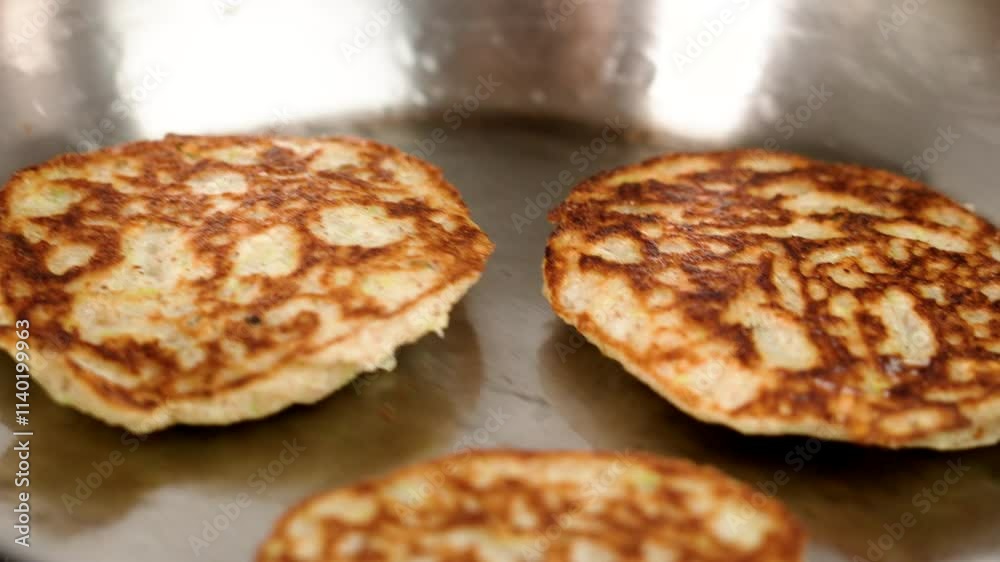 Freshly fried pancakes with golden brown crust in hot frying pan close up Freshly fried pancakes with golden brown crust in hot frying pan close up