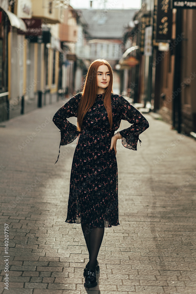 A woman stands in the middle of the street with her hands on her hips. The street is paved with cobblestones and surrounded by buildings with signs and windows. A woman stands in the middle of the street with her hands on her hips. The street is paved with cobblestones and surrounded by buildings with signs and windows.